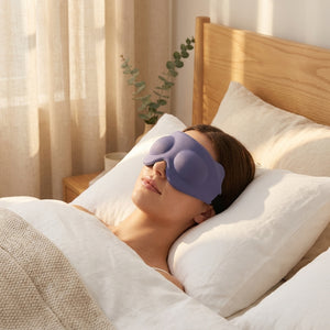Purple 3D memory foam sleep mask resting on white linen pillow in a serene golden-hour bedroom