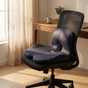 Black memory foam chair cushion fitted on designer office chair in calm minimalist home office at golden hour